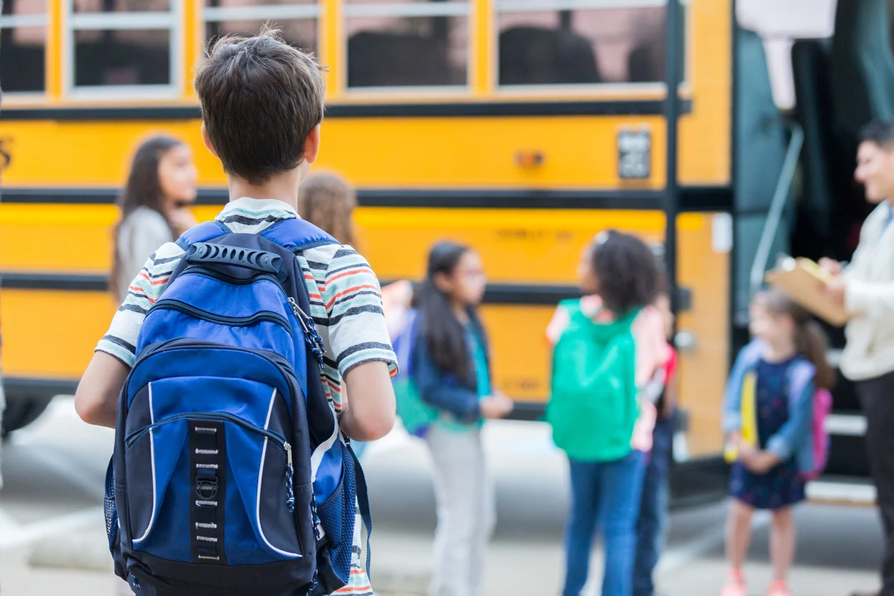 Estudantes com mochilas escolares