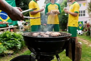 Mesa de churrasco com alimentos e bebidas durante transmissão de jogo da seleção brasileira