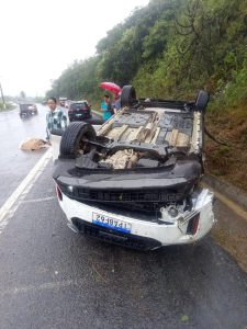 Carro branco capotado às margens de uma curva na rodovia federal BR-230 na Paraíba.