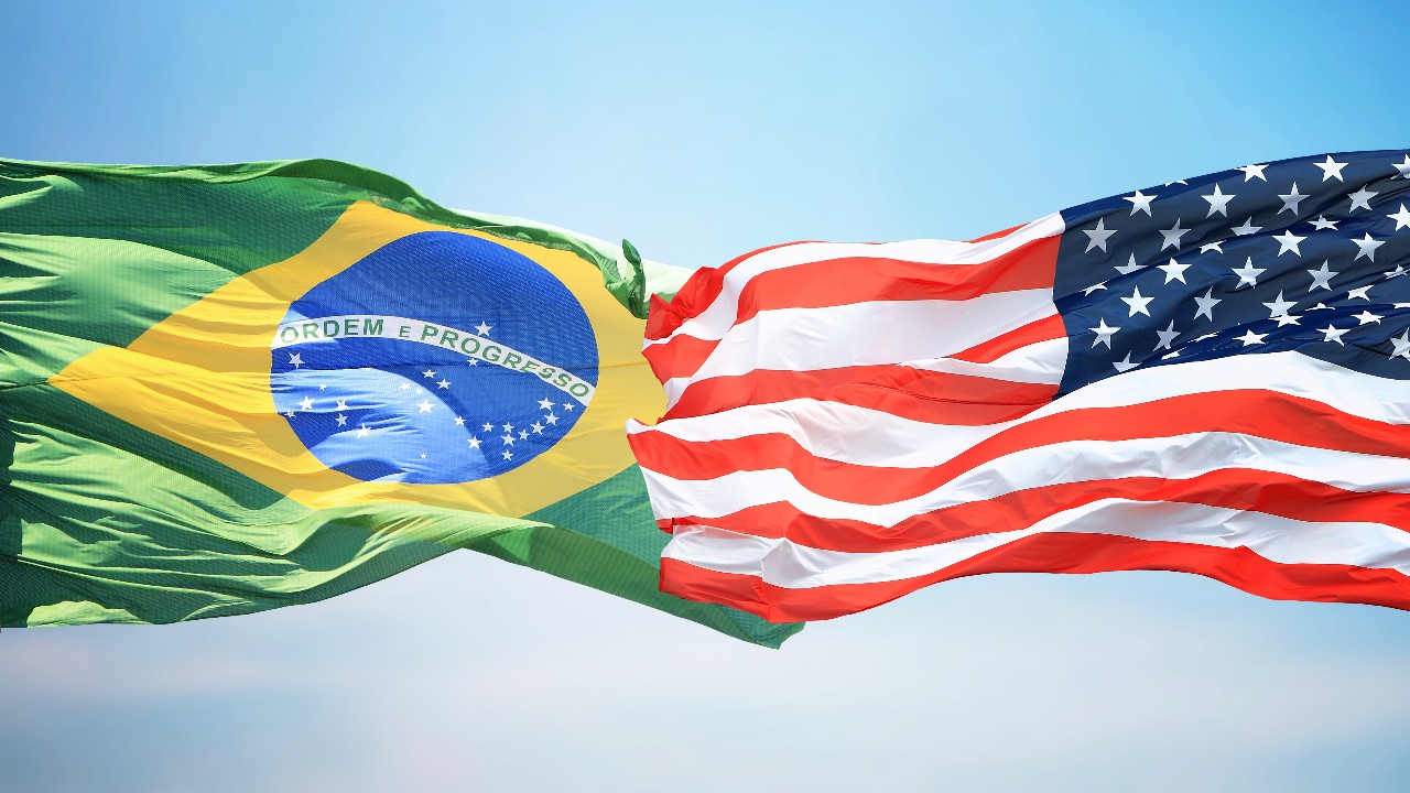 A nova tarifa dos EUA pode chegar a 37,5% em cobrança cumulativa, ameaçando US$ 12,5 bi em exportações do Brasil (Amcham).
