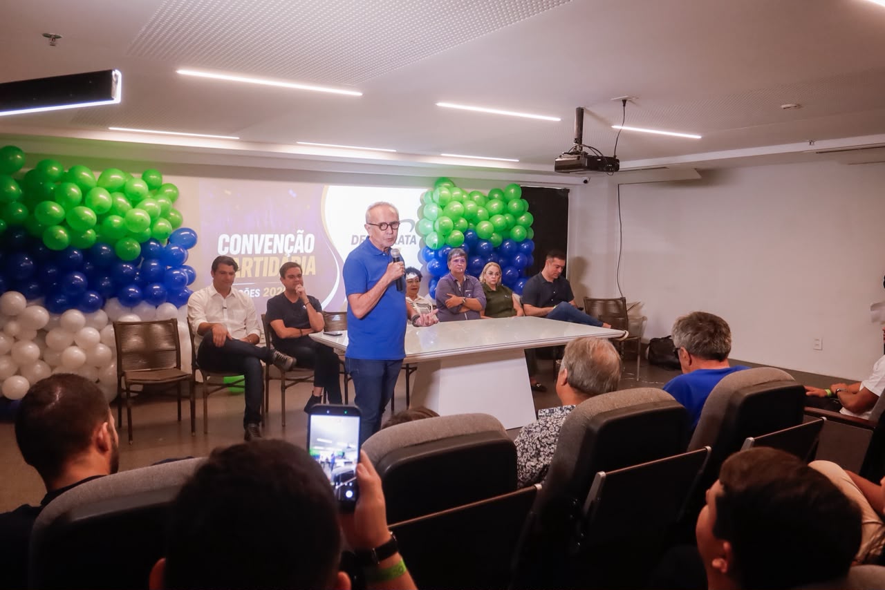 Cícero Lucena discursando no púlpito ao lado de Suêd Haidar e Janduhy Carneiro durante convenção partidária.